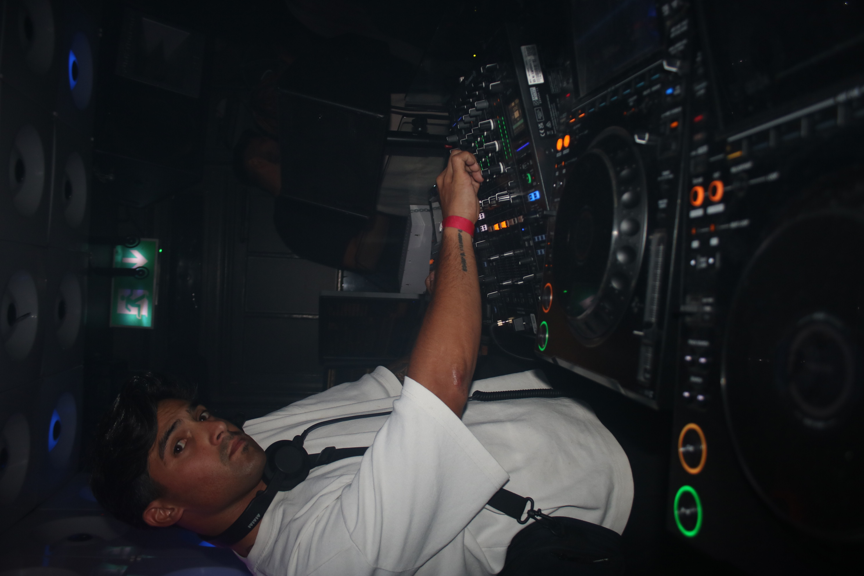 DJ dark scene with illuminated booth and kinetic lasers