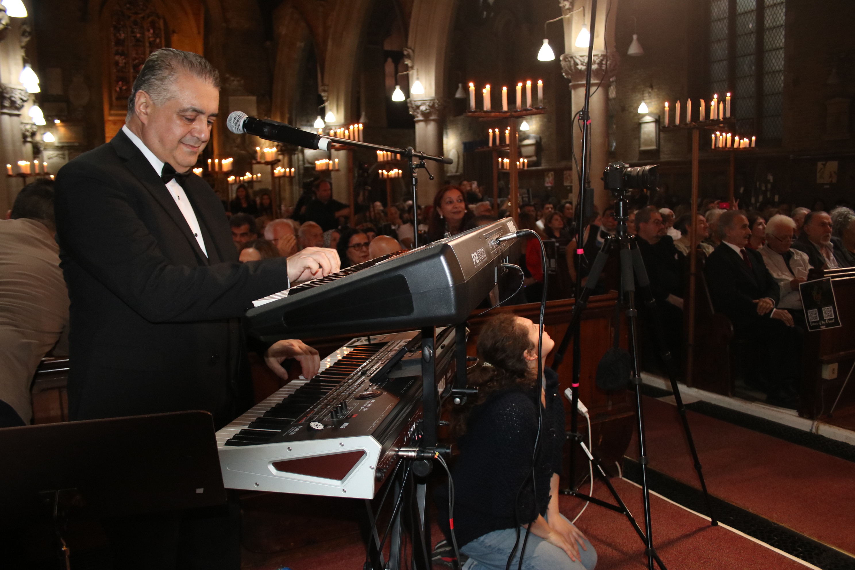 Live concert pianist performing at grand piano under stage lighting